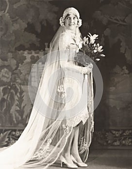 Bride carrying bouquet of lilies