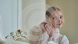 The bride corrects her earring.