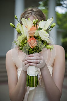 Bride covering her face with bouquet