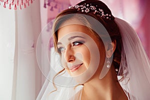 Bride with delicate face traits stands thoughtful