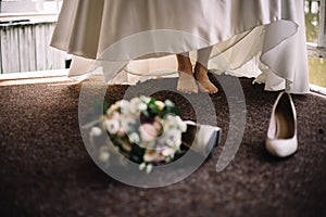 Bride detail soft bouquet and beige shoes. Concept of stylish wedding