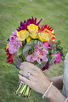 Bride displaying flowers and wedding ring