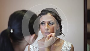 Bride doing makeup on the wedding day
