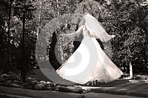 Bride doing pirouette in the park