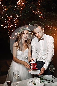 The bride dresed white and groom cut the wedding cake under a la