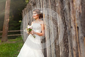 Bride in dress near wooden fence