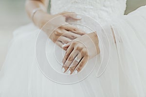 Bride dressed in wedding dress and her white hands