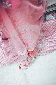 Bride dresses shoes before the wedding ceremony.