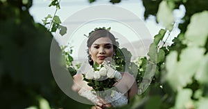 Bride, face and wedding with bouquet in garden for marriage, commitment and ceremony in park. Woman, portrait or love