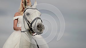 bride from fairytale, blonde woman is sitting on white horse, romantic wedding day