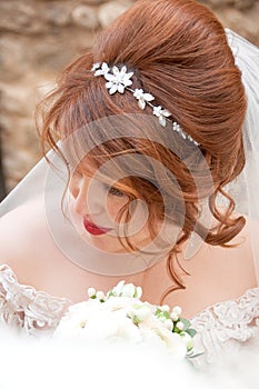 Bride with fashion wedding hairstyle and stylish hair accessory. Beautiful lace wedding dress.