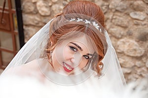 Bride with fashion wedding hairstyle and stylish hair accessory. Beautiful lace wedding dress.