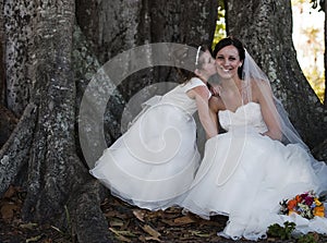 Bride and flower girl under tree