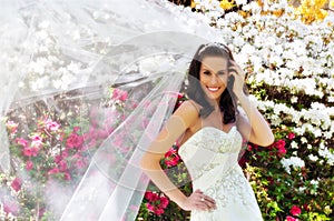 Bride in front of flowers with veil