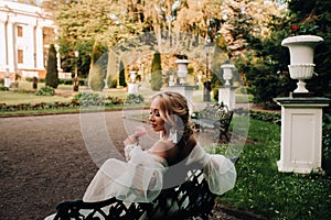 Bride in the garden, bride sitting on a bench, bride gathering, morning bride, white dress, put on earrings