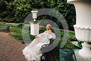 Bride in the garden, bride sitting on a bench, bride gathering, morning bride, white dress, put on earrings