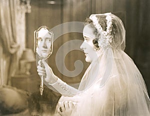 Bride gazing into hand mirror photo