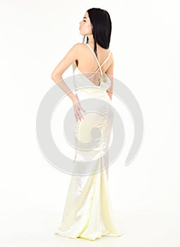 Bride, girl in graceful dress. Fashion wedding concept. Woman in elegant white dress with nude back, white background