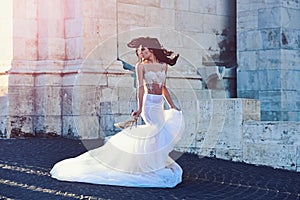 Bride girl at wedding ceremony in castle. Woman at stone ancient tower in summer. Sexy girl in white dress with stylish