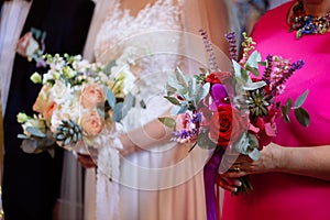 Bride and godmother holding wedding bouquets during wedding ceremony