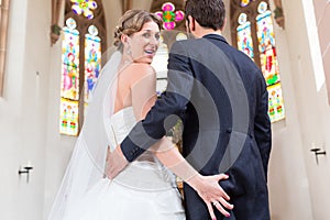 Bride grabbing of groom at wedding in church