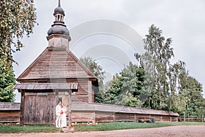 Bride and groom on the background of the old wooden church