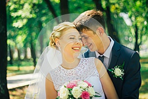 The bride and groom on the background of the park alley