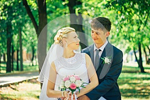 The bride and groom on the background of the park alley