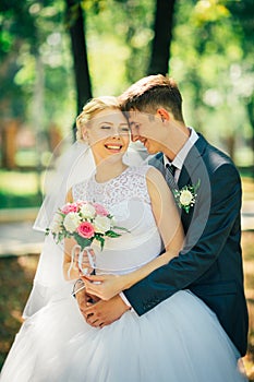 The bride and groom on the background of the park alley