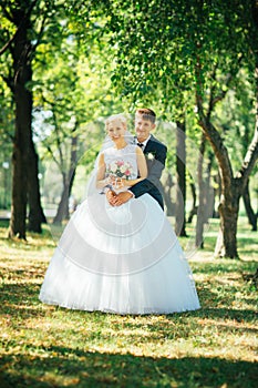 The bride and groom on the background of the park alley