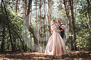 Bride and groom on the background of trees and woods in full growth