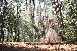 Bride and groom on the background of trees and woods in full growth