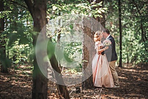 Bride and groom on the background of trees and woods in full growth