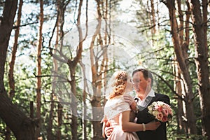 Bride and groom on the background of trees and woods in full growth