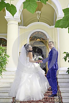 Bride and groom with a bouquet of flowers on the stairs