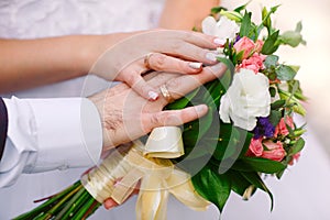 Bride and groom with a bouquet in hands, close-up.