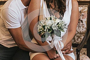 Bride and groom in a cafe. wedding bouquet on a wooden table in a restaurant bride and groom hold each other`s hands