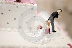 Bride and Groom cake toppers on a wedding cake photo