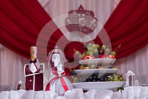 The bride and groom, champagne. Fruits. Decoration on bottles with champagne at the wedding.