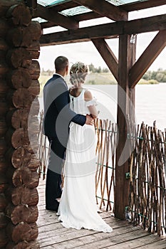 Bride and groom in a country house looking into distance on the lake