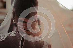 Bride and groom covered with veil close-up. Interracial marriage. Asian bride and groom