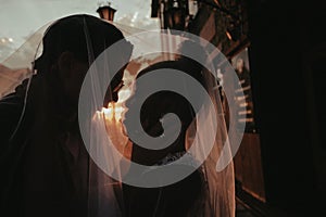 Bride and groom covered with veil close-up. Interracial marriage. Asian bride and groom