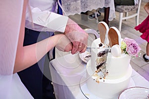 Bride and groom cut a wedding cake together in a restaurant