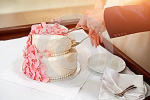 Bride and groom cutting their wedding cake decorated with orchids.