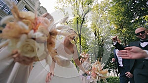 Bride and groom dance a dance together with their girlfriends. Happy young people dancing. Joyful wedding party running