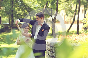 Bride and groom dancing in the park