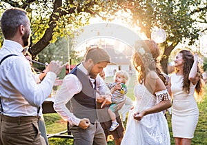 Bride and groom dancing at wedding reception outside in the backyard.