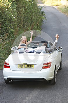 Bride And Groom Driving Away In Decorated Car