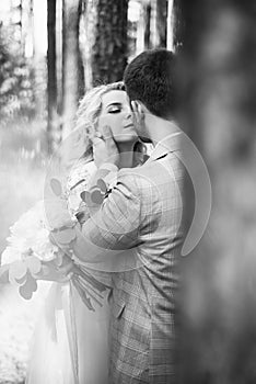 The bride and groom embrace in the forest on the wedding day. wedding ceremony. selective focus.