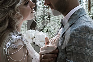 The bride and groom embrace in the forest on the wedding day. wedding ceremony. selective focus.